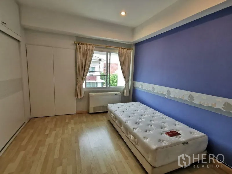 ทาวน์เฮาส์ ให้เช่าหรือขายในYan Nawa, Bangkok - ห้องนอนสว่าง เตียงเดี่ยว ผนังสีฟ้า หน้าต่าง และตู้บิวต์อิน