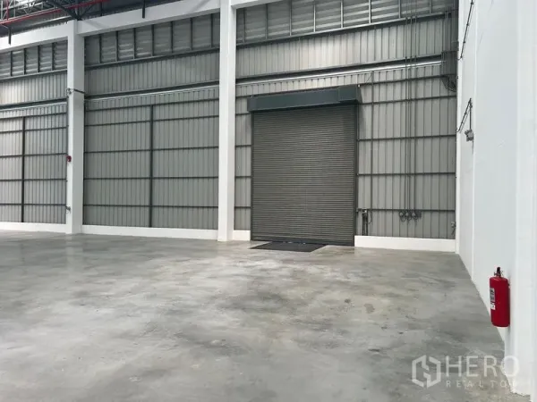 Factory for rent in Bang Pakong, Chachoengsao - Bright factory interior with polished concrete floor, high ceiling and a large roller shutter loading door.