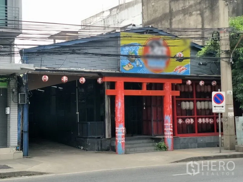 零售空间 出租在Khlong Toei, Bangkok - 临街店铺立面，红色鸟居风格入口与大型展示窗。