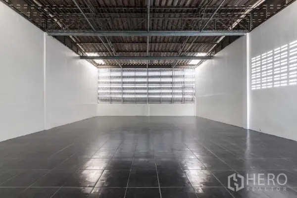 Home Office for sale in Bang Kho Laem, Bangkok - Warehouse-style open hall with black tile flooring and ventilated window wall.