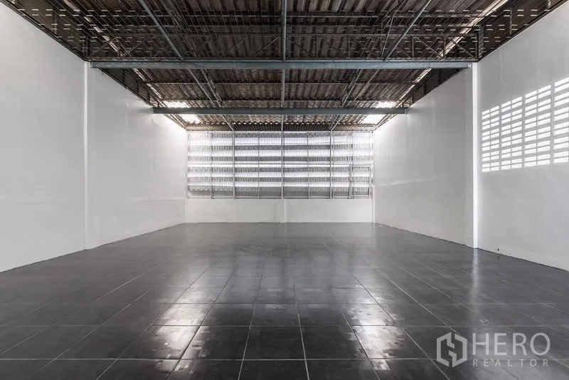 Home Office for sale in Bang Kho Laem, Bangkok - Warehouse-style open hall with black tile flooring and ventilated window wall.