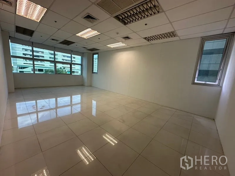Office Space for rent in Ratchathewi, Bangkok - Private corner room with tiles, windows on two sides and an acoustic ceiling.