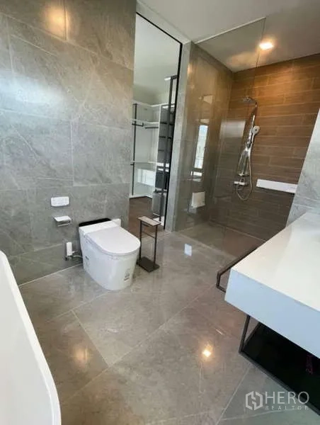 Detached House for rent in Samut Prakan - Contemporary bathroom with glass shower, gray tiles and sleek fixtures.
