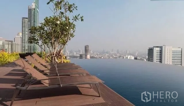 Condominium for rent in Khlong San, Bangkok - Rooftop infinity pool with sun loungers and panoramic Bangkok skyline views.