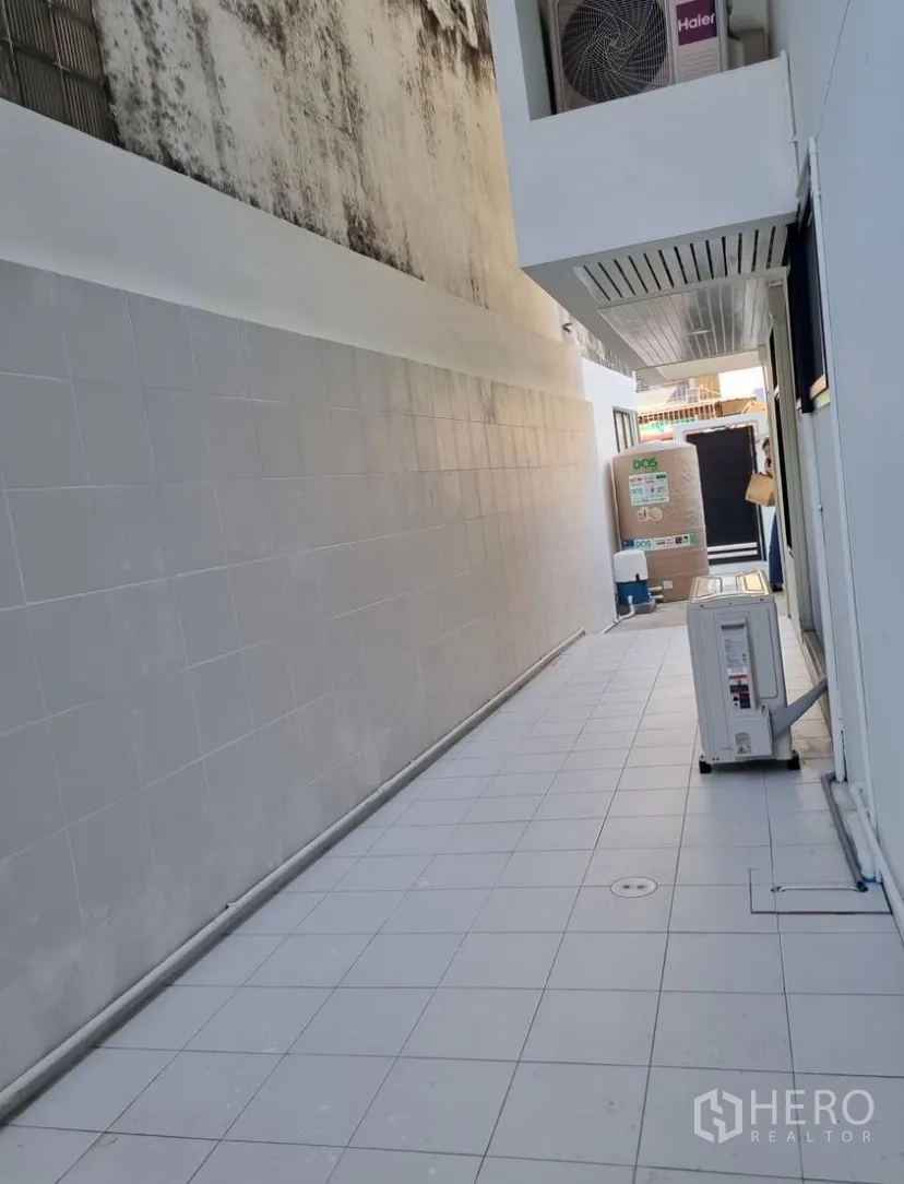 Detached House for rent in Suan Luang, Bangkok - Tiled side service yard with air-conditioning compressors and a water tank.