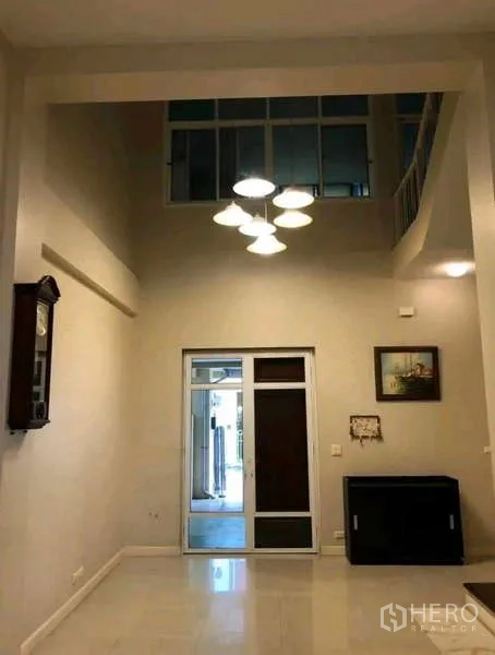 ทาวน์เฮาส์ ให้เช่าในPhra Khanong, Bangkok - โถงทางเข้าพร้อมชั้นลอย โคมไฟแขวน และประตูกระจกด้านหลัง