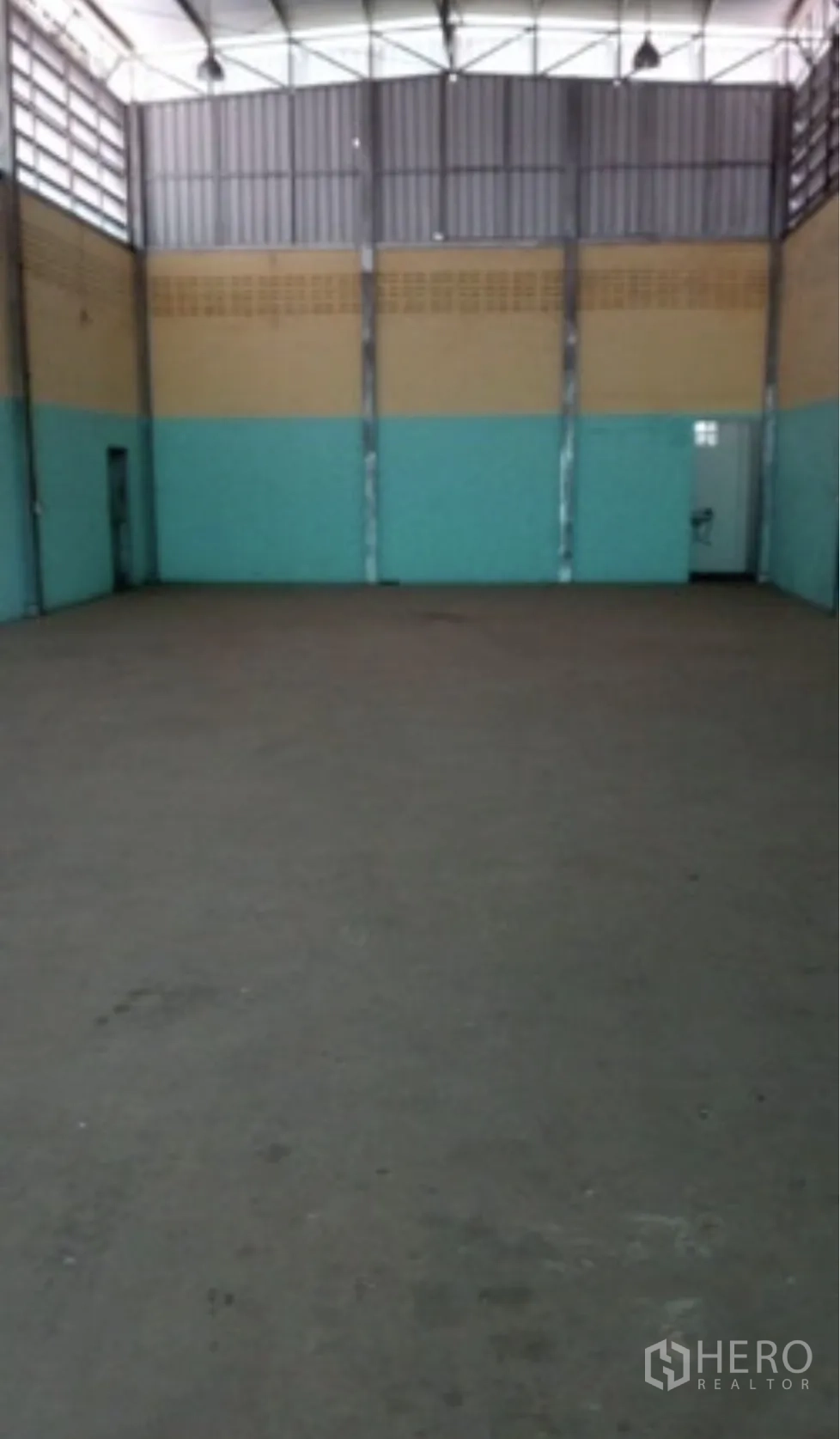 โกดัง for rent in Mueang Nonthaburi, Nonthaburi - ภายในโกดังเพดานสูง โครงหลังคาเหล็ก ผนังทูโทน และพื้นคอนกรีตโล่งสำหรับจัดเก็บสินค้า