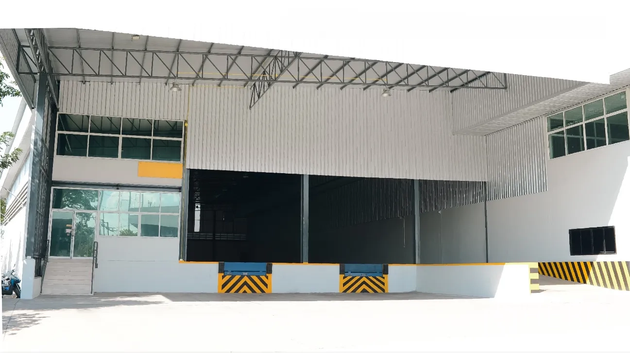 Factory for rent in Si Racha, Chon Buri - Factory exterior with covered loading zone, two dock levelers, and glass entry door.