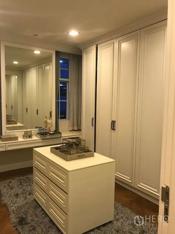 Townhouse for sale in Watthana, Bangkok - Walk-in closet with island drawers, full-height cabinets and a window.
