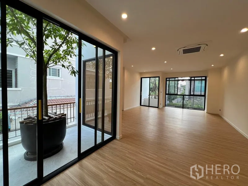 สำนักงานที่บ้าน ขายในPhra Khanong, Bangkok - ห้องอเนกประสงค์พื้นไม้ ประตูกระจกบานเลื่อน และระเบียงปลูกต้นไม้ในกระถาง.