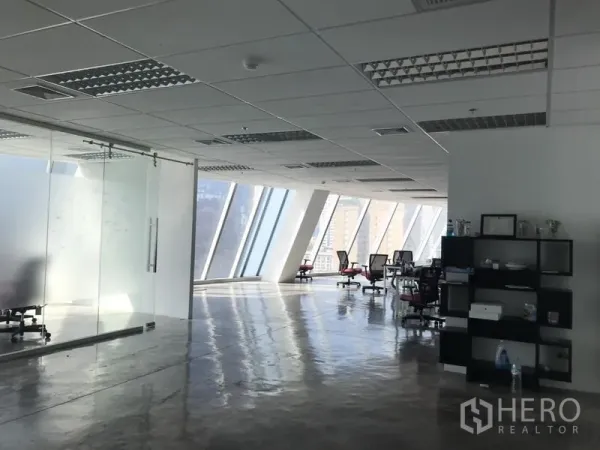 办公空间 出租在Khlong Toei, Bangkok - 明亮办公楼层，斜面幕墙窗与玻璃会议室，工位可眺望城市天际线。