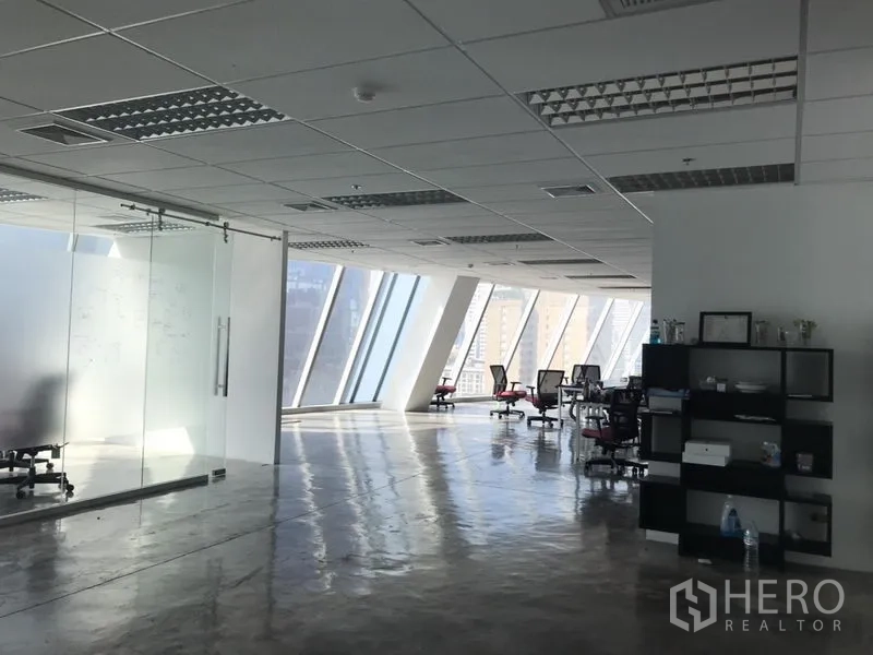 办公空间 出租在Khlong Toei, Bangkok - 明亮办公楼层，斜面幕墙窗与玻璃会议室，工位可眺望城市天际线。