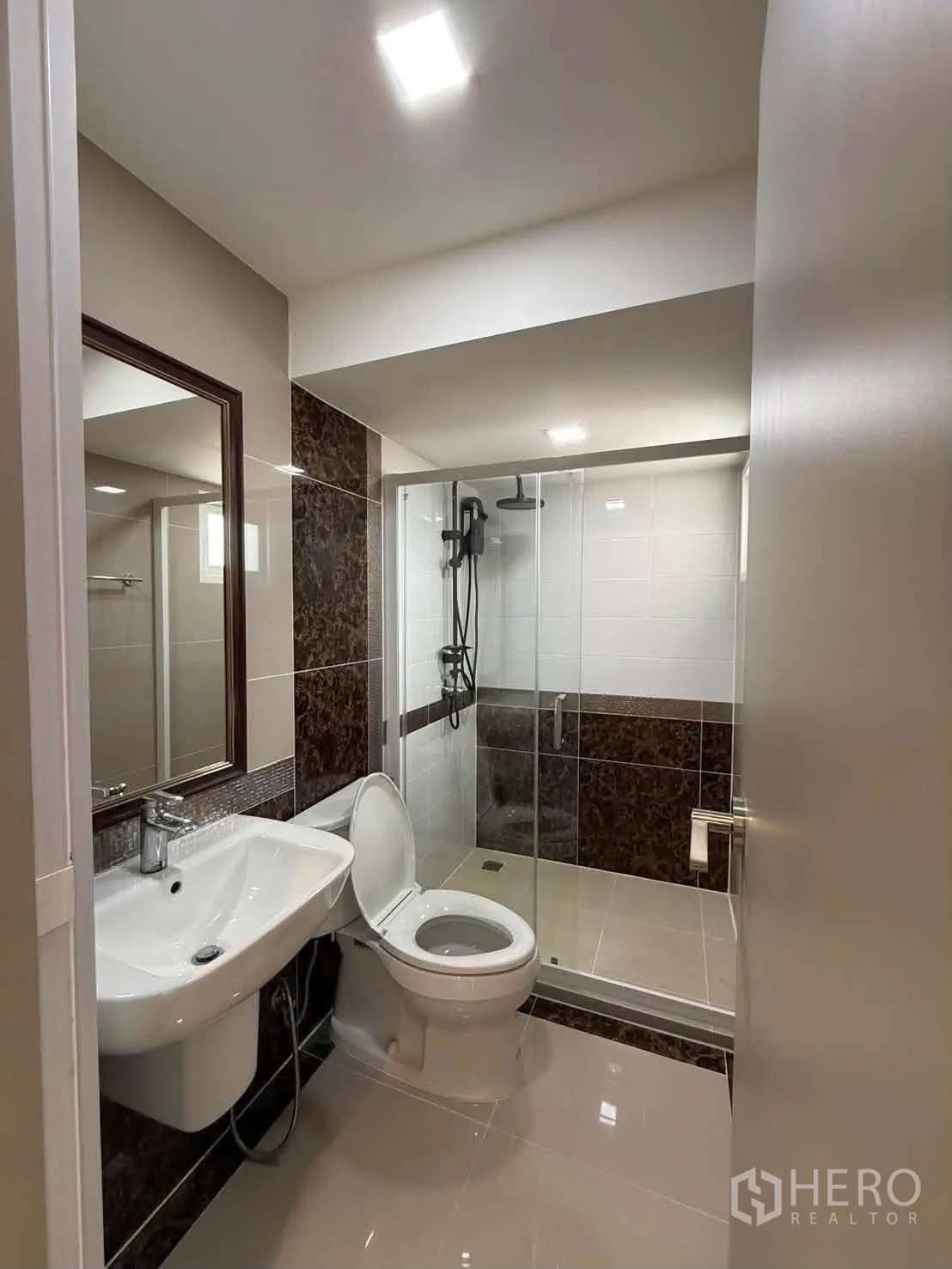 Detached House for rent in Bang Phli, Samut Prakan - Bathroom with glass-enclosed shower, toilet, and sink with mirror.