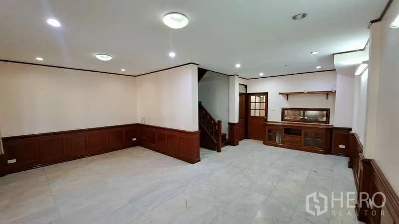 ทาวน์เฮาส์ ให้เช่าในWatthana, Bangkok - พื้นที่นั่งเล่นชั้นล่าง กรุกำแพงไม้ บันได และตู้บิลท์อิน