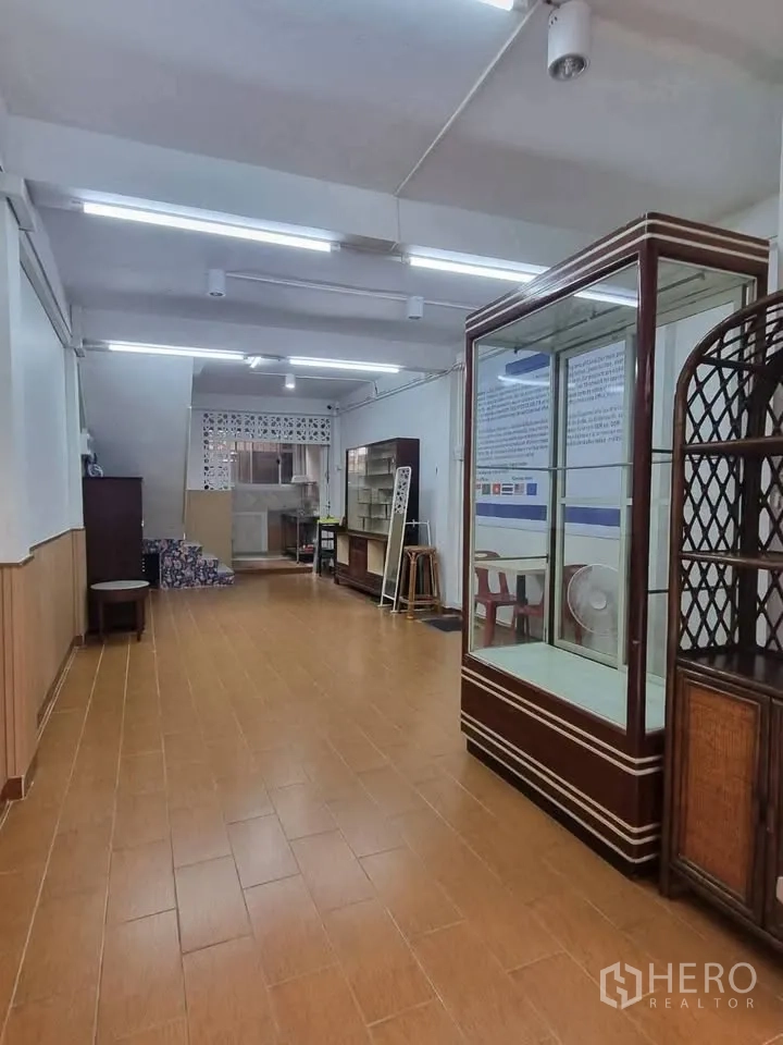 ตึกแถว for rent in Phra Khanong, Bangkok - โถงชั้นล่างยาว ปูกระเบื้อง มีตู้กระจกและทางขึ้นบันไดด้านหลัง.
