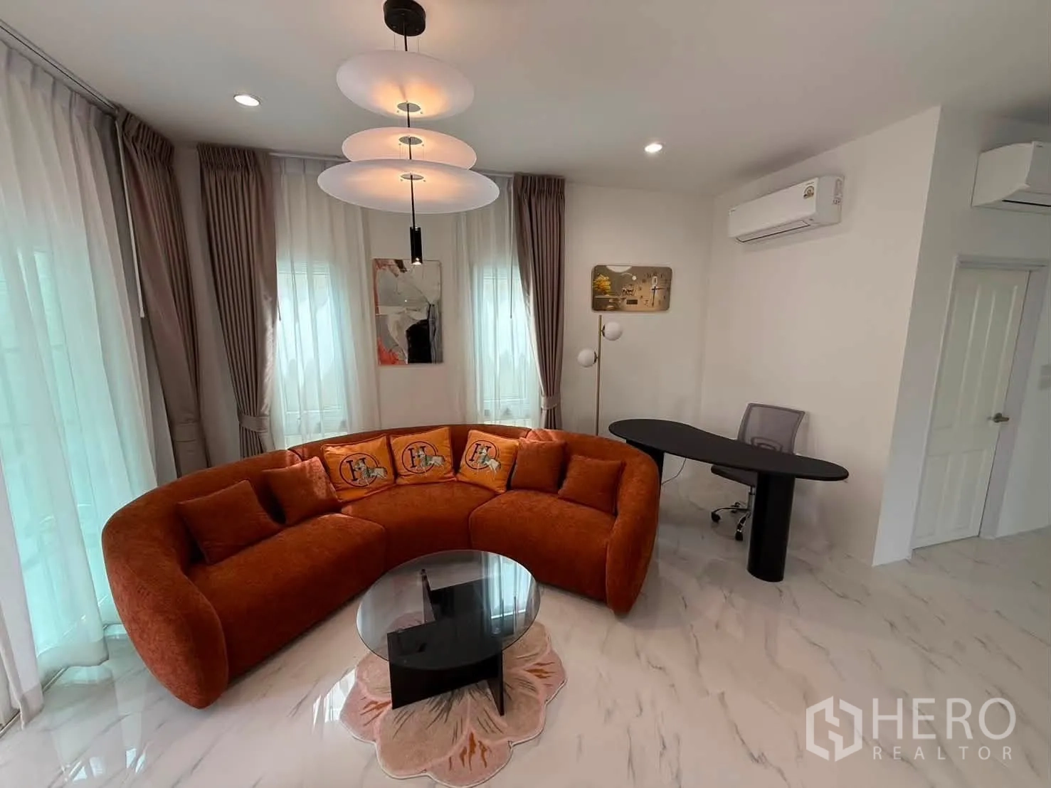 Detached House for rent in Bang Phli, Samut Prakan - Corner lounge with orange curved sofa, glass coffee table and desk.
