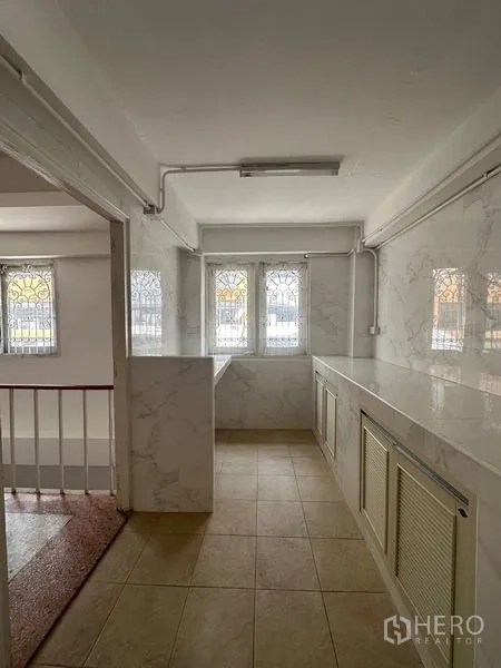 อาคารพาณิชย์ ให้เช่าในBangkok - พื้นที่แพนทรีสว่าง เคาน์เตอร์บิวท์อินยาว หน้าต่างหลายบาน และพื้นกระเบื้อง.