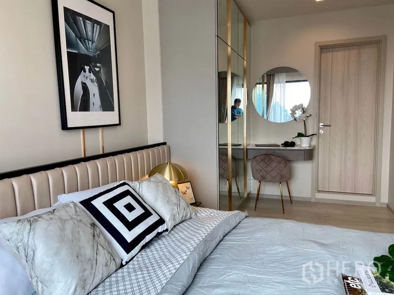 公寓 出租在Pathum Wan, Bangkok - 卧室细节：软包床头、几何抱枕与镜面衣柜。