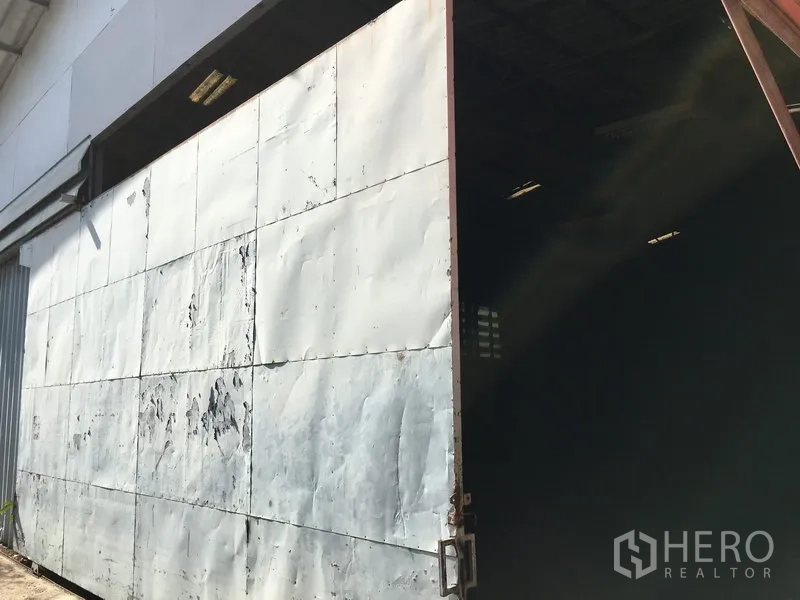 Warehouse for rent in Suan Luang, Bangkok - Heavy-duty sliding steel door providing truck access to the warehouse.