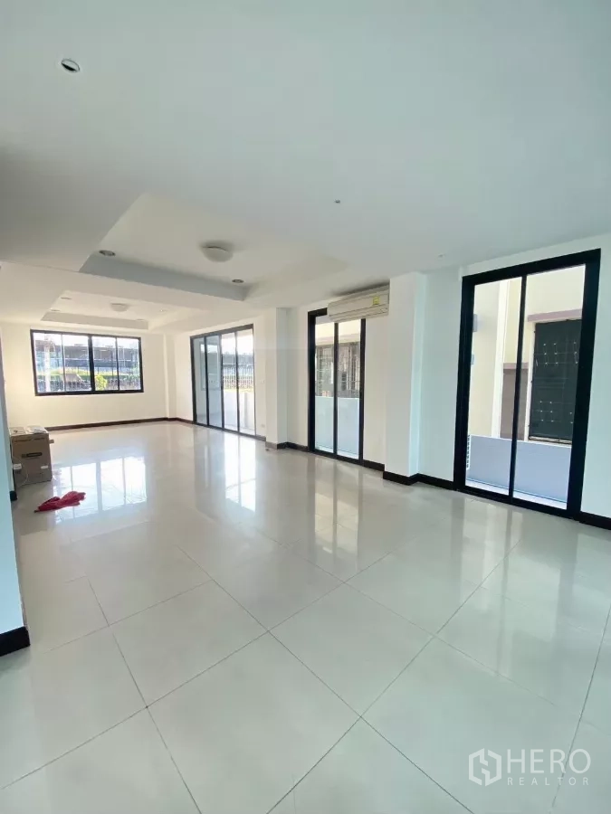 Home Office for rent in Wang Thonglang, Bangkok - Bright open-plan ground floor with glossy tile flooring and full-height sliding glass doors.