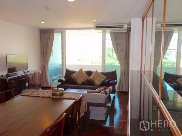 คอนโด ให้เช่าหรือขายในWatthana, Bangkok - ห้องนั่งเล่นสว่าง เปิดออกสู่ระเบียง กระจกบานใหญ่ ม่านทึบ และตู้วางทีวี