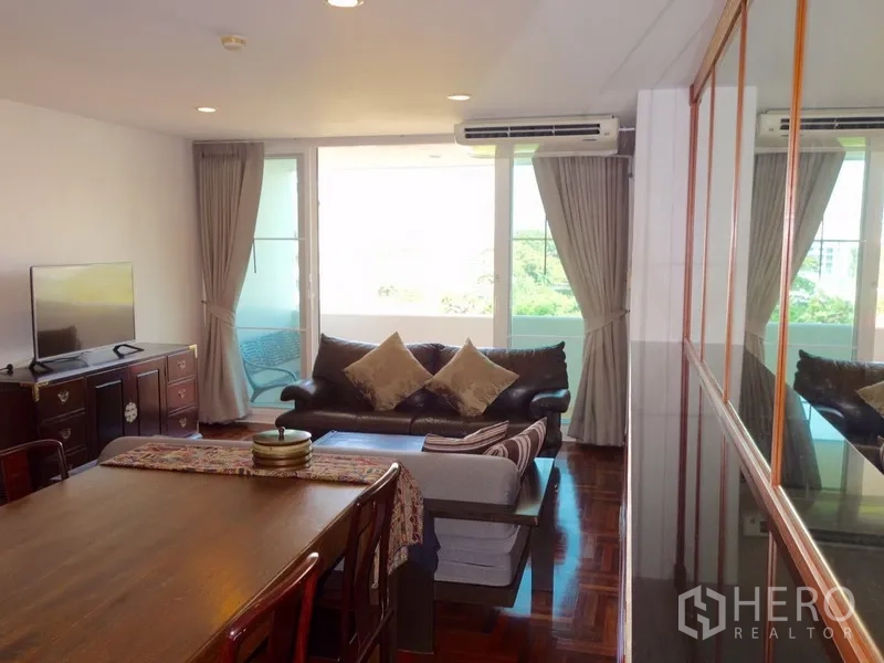 คอนโด ให้เช่าหรือขายในWatthana, Bangkok - ห้องนั่งเล่นสว่าง เปิดออกสู่ระเบียง กระจกบานใหญ่ ม่านทึบ และตู้วางทีวี