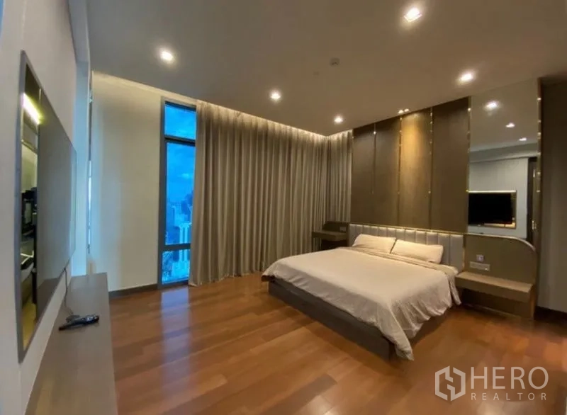 公寓 出租在Khlong Toei, Bangkok - 宽敞主卧，木地板、嵌灯，落地窗配长窗帘，城市景观。