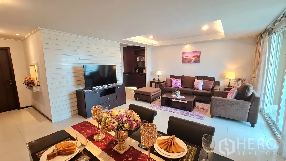 อพาร์ทเมนท์ ให้เช่าในWatthana, Bangkok - มุมมองห้องนั่งเล่น ทีวีคอนโซล ชุดโซฟา และประตูบานเลื่อนออกสู่ระเบียง