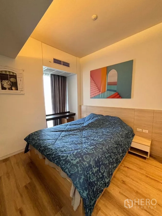 คอนโด ให้เช่าหรือขายในPhaya Thai, Bangkok - ห้องนอนที่สอง พื้นไม้ หน้าต่าง และงานศิลป์สีสันเหนือเตียง