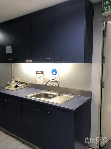 สำนักงาน ให้เช่า - แพนทรีขนาดกะทัดรัด มีอ่างล้างจาน ไฟใต้ตู้ และตู้ลอยสีน้ำเงินเข้ม
