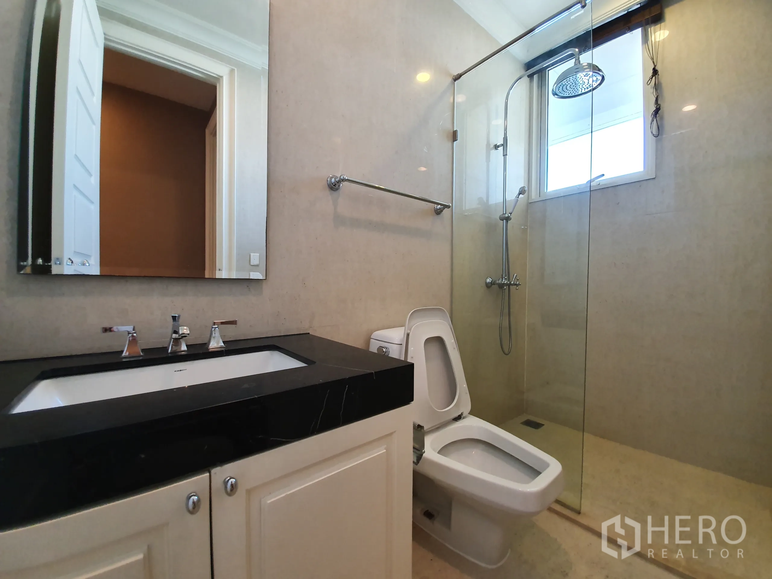 公寓 出租在Watthana, Bangkok - 客卫配玻璃围合雨淋花洒、坐便与黑色台面洗手台。