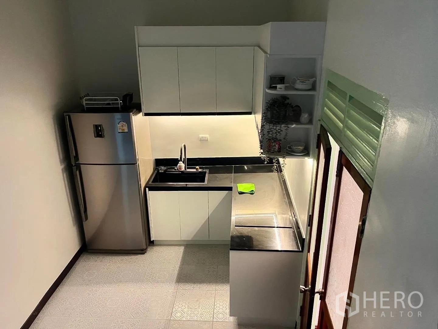 Shophouse for rent in Bang Rak, Bangkok - Compact kitchen with stainless fridge, sink, and white cabinetry.