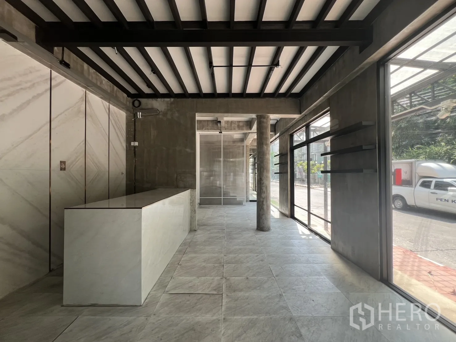 店屋 出租在Watthana, Bangkok - 店内长吧台、展示层板与通高玻璃窗。