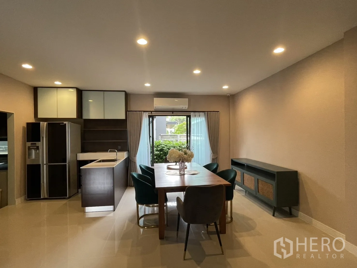 Detached House for rent in Bang Kapi, Bangkok - Dining room with six-seat table beside open kitchen and island.
