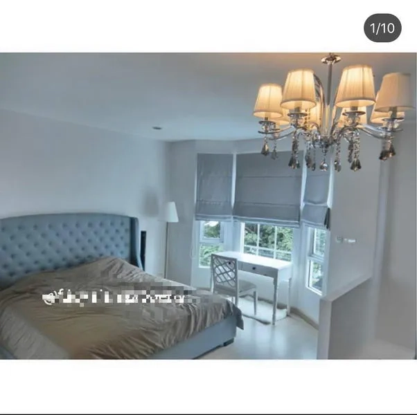 联排别墅 出租在Bang Kapi, Bangkok - 主卧带飘窗与水晶吊灯，设书桌可眺望绿意。