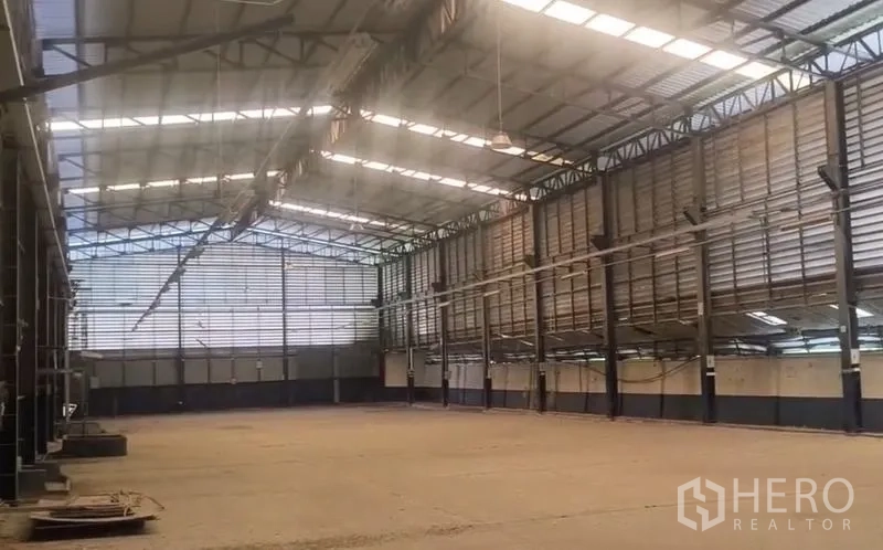 Warehouse for rent in Lat Lum Kaeo, Pathum Thani - Spacious high-ceiling warehouse interior with steel trusses and skylights.
