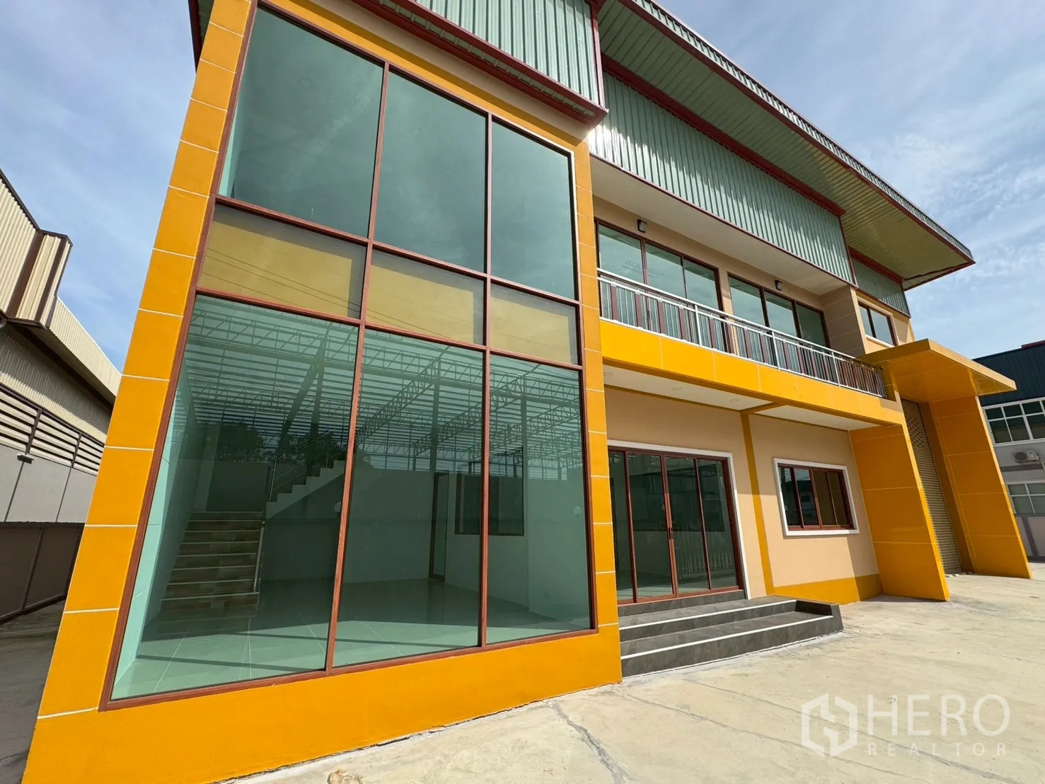 工厂 for sale in Mueang Samut Sakhon, Samut Sakhon - 办公室正立面为落地玻璃，设台阶与二层阳台。