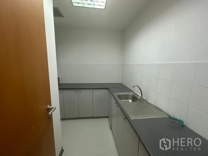 สำนักงาน ให้เช่าในPhaya Thai, Bangkok - แพนทรีสำนักงานขนาดกะทัดรัด มีอ่างล้างจาน เคาน์เตอร์สีเทาและผนังกระเบื้องสีขาว