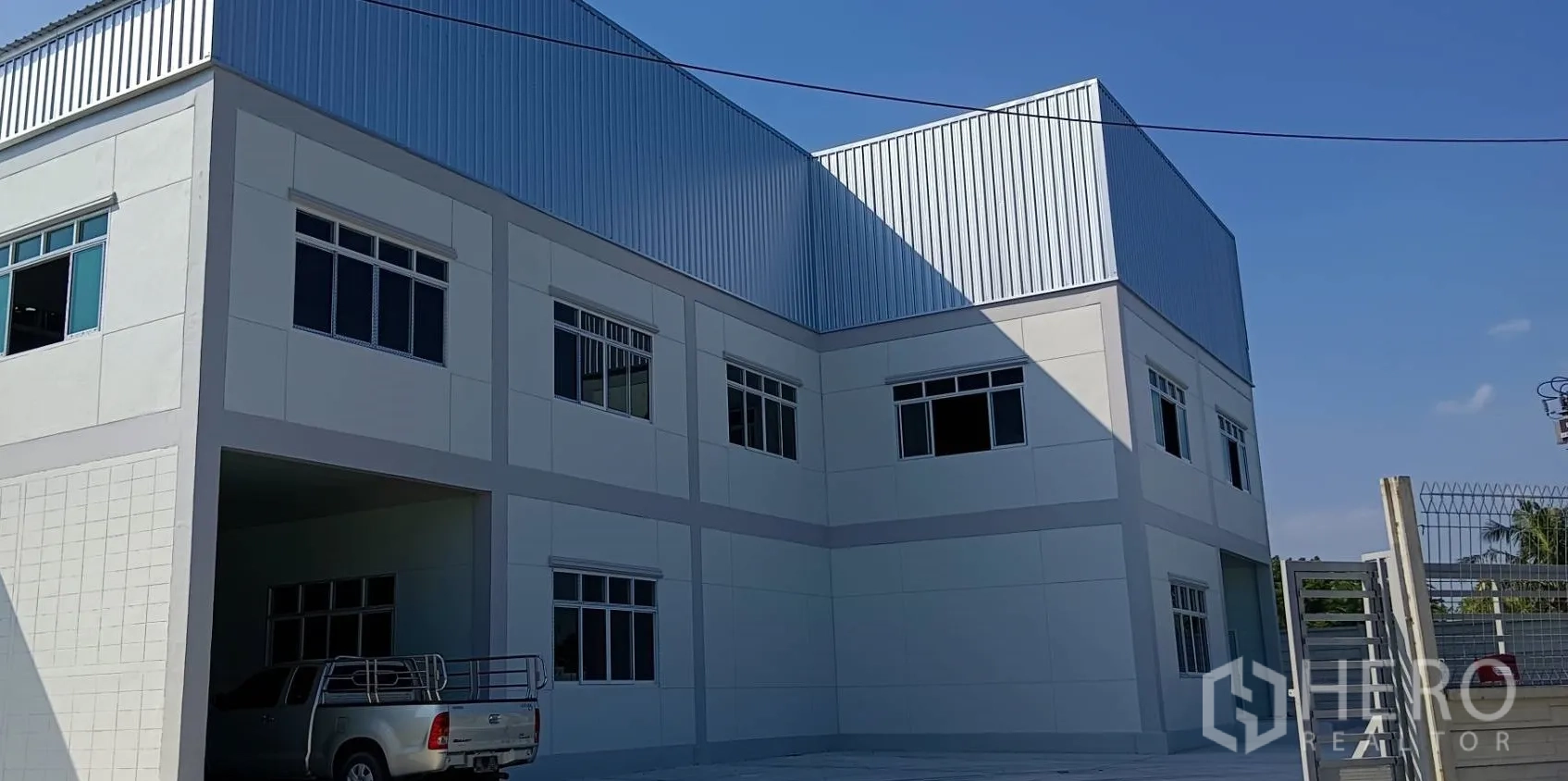 货栈 出租或出售在Lam Luk Ka, Pathum Thani - 仓库立面近景，金属覆层与多扇窗户。