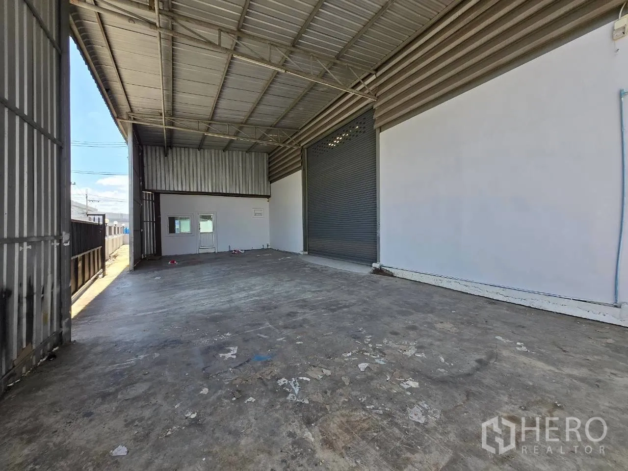 โกดัง for rent or sale in Mueang Samut Sakhon, Samut Sakhon - ชานโหลดคลุมหลังคาพร้อมประตูม้วนและช่องหน้าต่างสำนักงาน