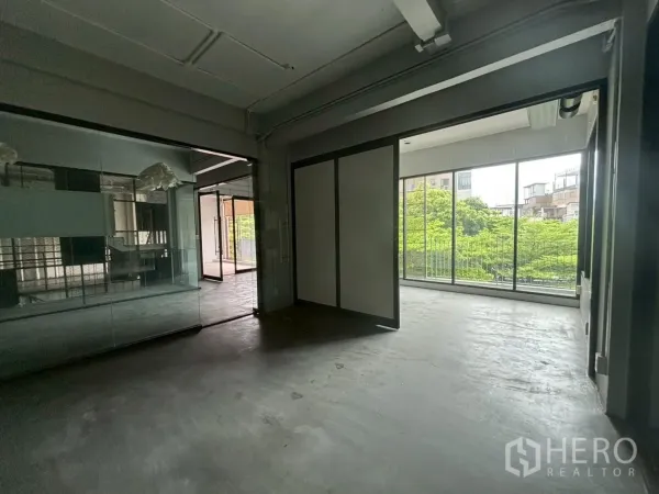 สำนักงาน ให้เช่า - มุมสำนักงานพร้อมหน้าต่างเต็มบาน มองเห็นวิวเมืองและต้นไม้เขียวชอุ่ม.