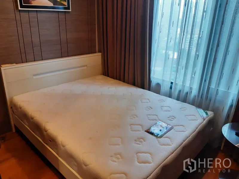 公寓 出租在Khlong Toei, Bangkok - 温馨卧室，配大床、纹理背景墙与带薄纱的落地窗。