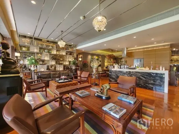 Condominium for sale in Yan Nawa, Bangkok - Open-plan lounge with marble island kitchen, glass display shelving and hardwood floors.