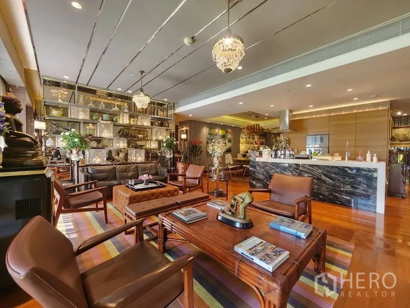 Condominium for sale in Yan Nawa, Bangkok - Open-plan lounge with marble island kitchen, glass display shelving and hardwood floors.