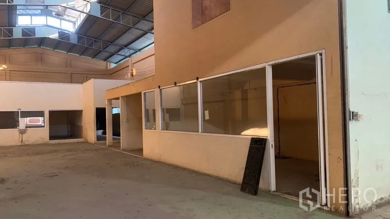 Warehouse for rent in Mueang Nakhon Pathom, Nakhon Pathom - Internal office pods with glass windows set inside the warehouse beneath skylight panels.