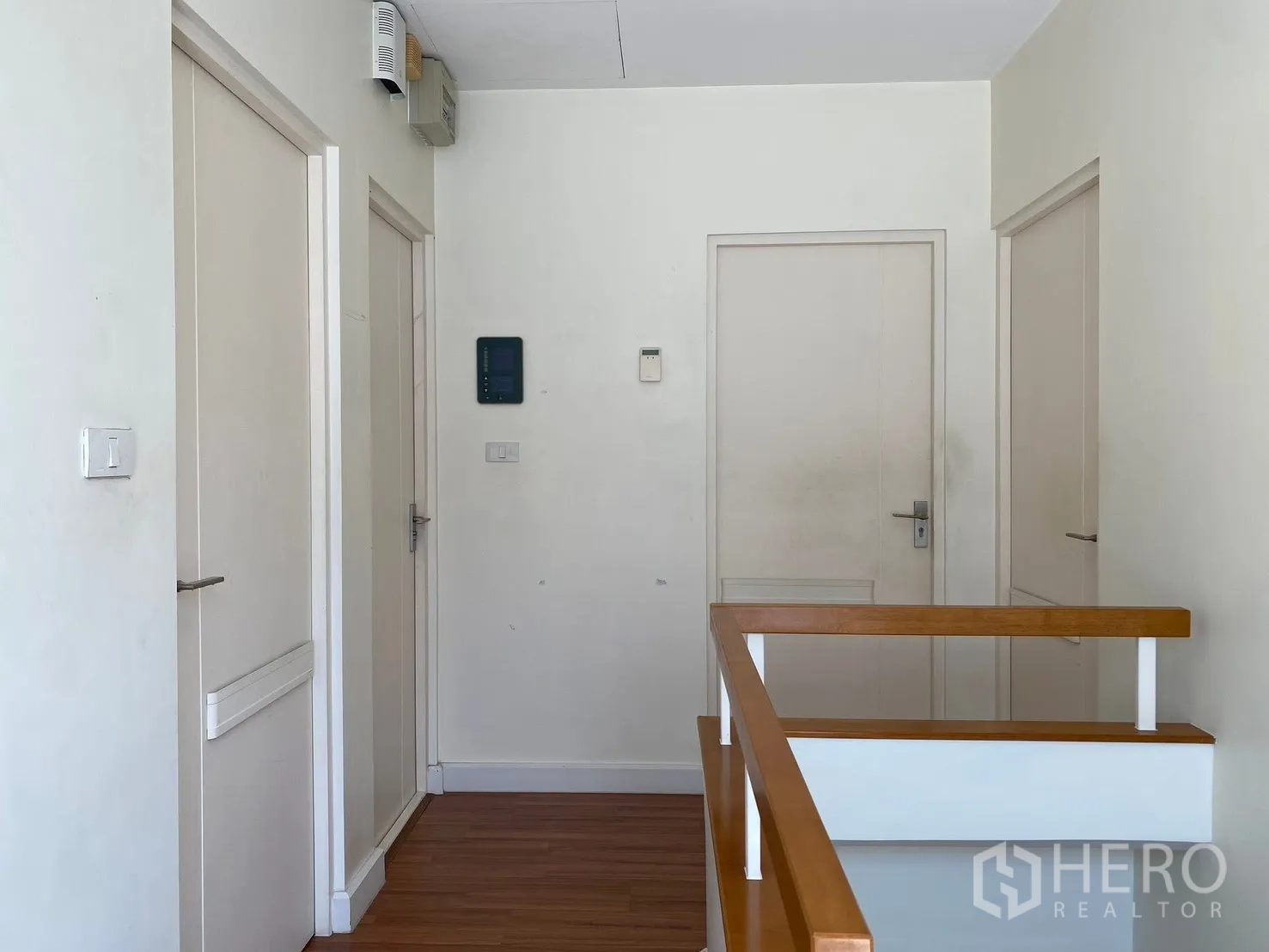 Detached House for rent in Prawet, Bangkok - Upstairs landing with several doors and a wooden handrail.