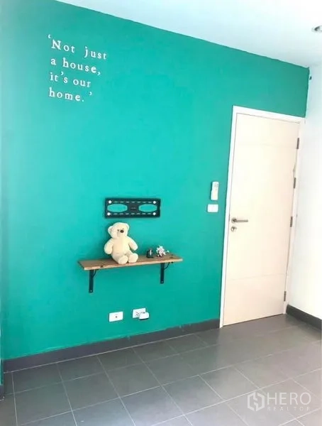 ทาวน์เฮาส์ ให้เช่าในSuan Luang, Bangkok - มุมห้องนั่งเล่น ผนังทาสีเขียวทีล ชั้นวาง และประตู