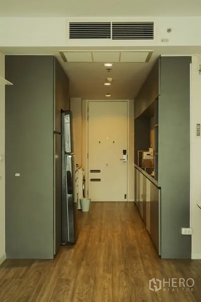 公寓 出租在Bang Rak, Bangkok - 入户走廊配开放式简易厨房，木地板与高柜