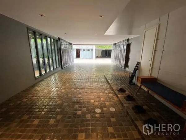 บ้าน ขายในPhaya Thai, Bangkok - ทางรถเข้าในร่มปูพื้นกระเบื้อง พร้อมผนังกระจกบานเลื่อนสู่ลานภายในสว่างโปร่ง