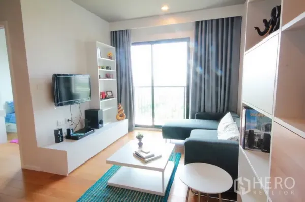 公寓 出租在Watthana, Bangkok - 客厅设L型沙发、影音柜与大幅推拉玻璃门